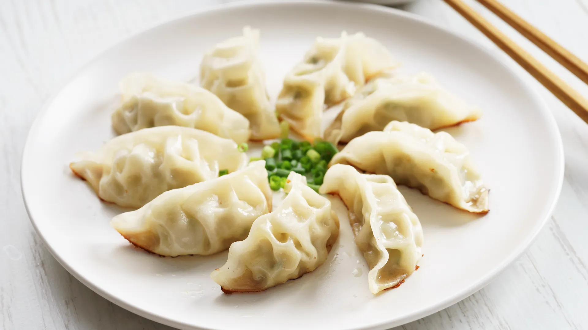 Plated crispy dumplings garnished with chopped green onion at Dumpling Legend, a Chinese Restaurant in Lakewood